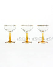 Load image into Gallery viewer, Set of three frosted glass champagne coupes with an amber handle. Shop the range of hand sourced glassware and ceramics by Rebecca Arts online.